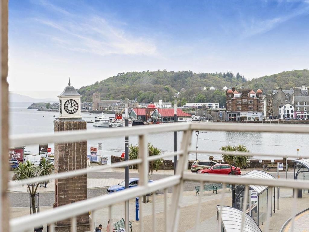 a balcony with a clock tower and a body of water at 1 Bed in Oban oc-96079 in Oban