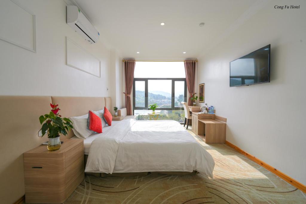 a bedroom with a bed and a large window at Cong Fu Hotel in Bắc Hà