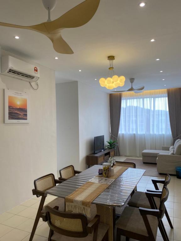 a living room with a table and chairs and a couch at De' Haven Stay - 10minutes to Airport Tawau in Tawau