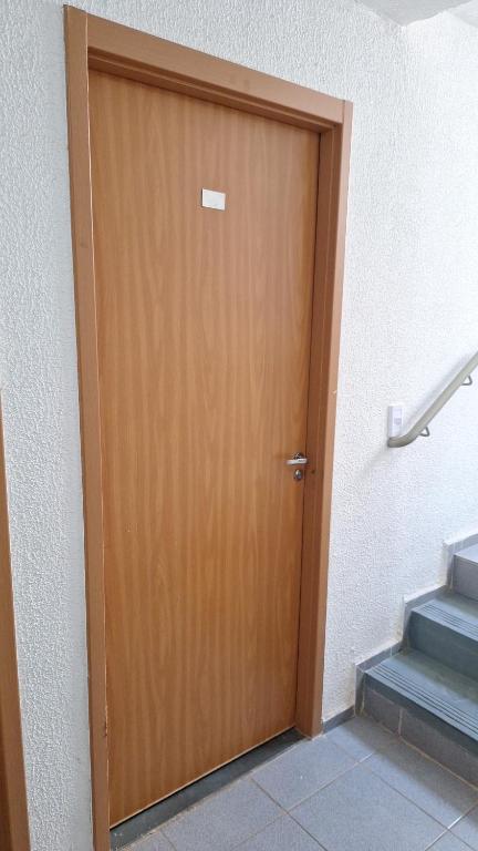 a wooden door in a room with stairs at Charles in Presidente Prudente