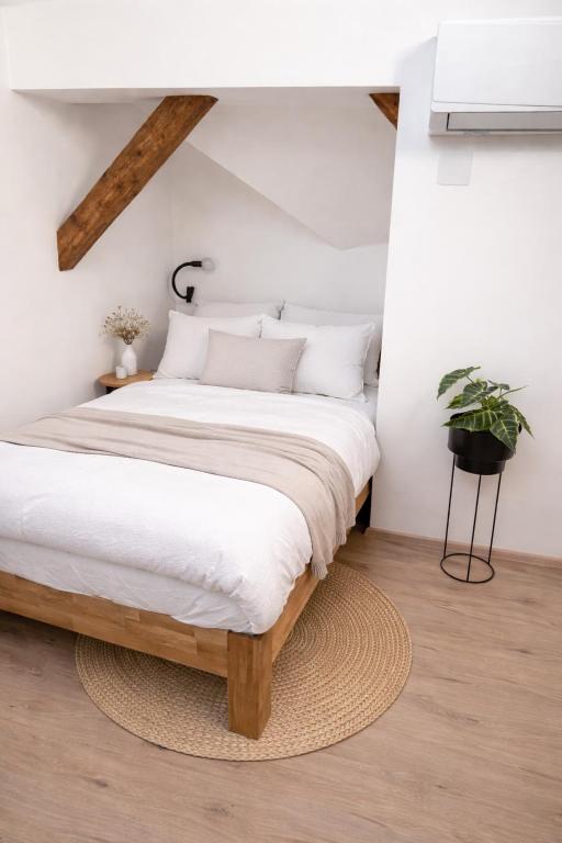 a bedroom with a large bed with white sheets at Ekoviki2 in Kranj