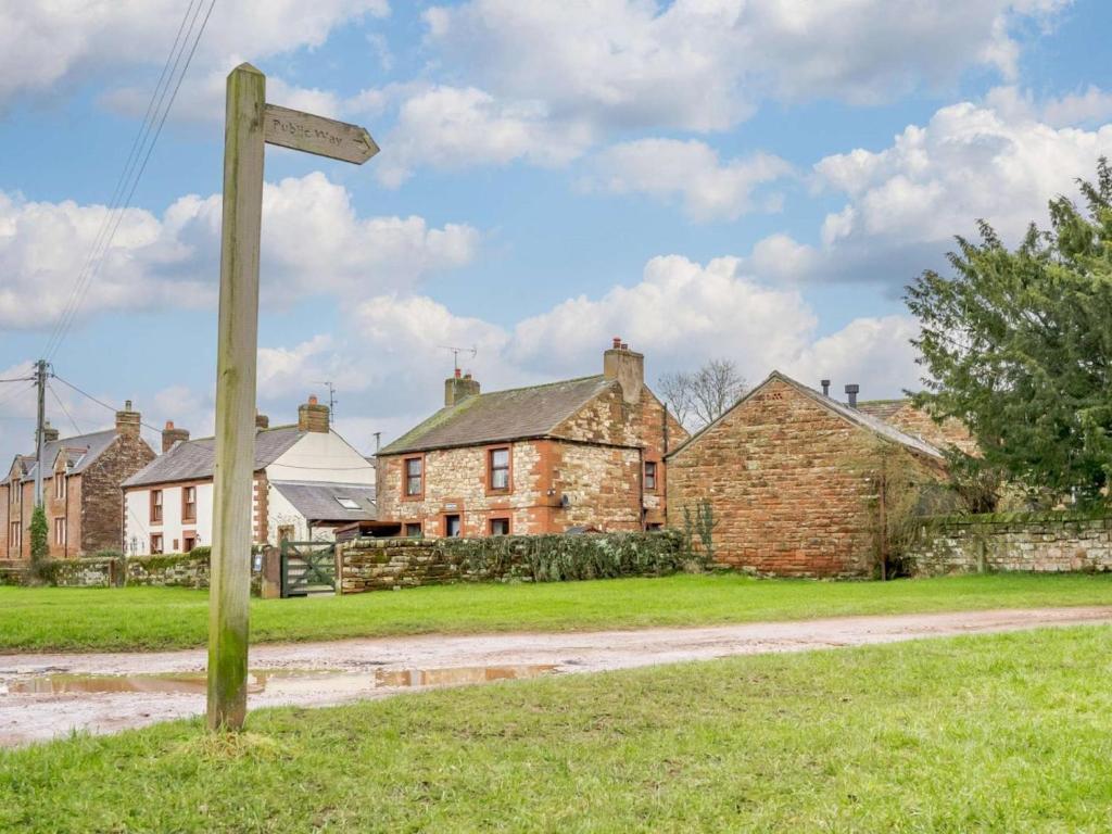 an old house with a street sign in front of it at 1 Bed in Penrith oc-90417 in Kirkoswald