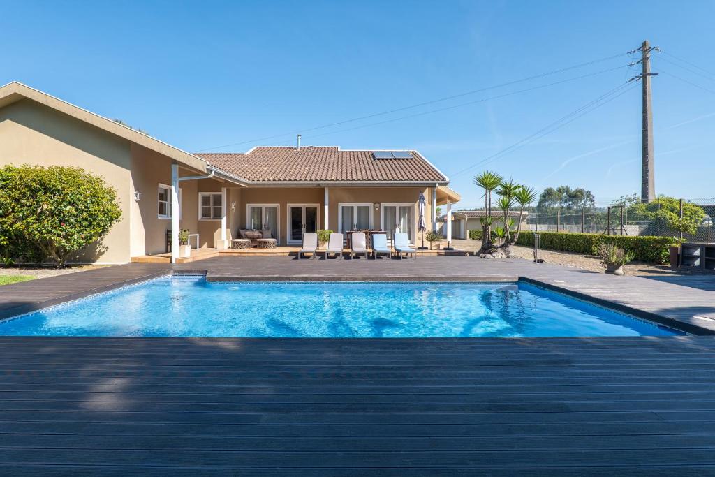 a swimming pool in front of a house at Villa Aqueduto in Póvoa de Varzim