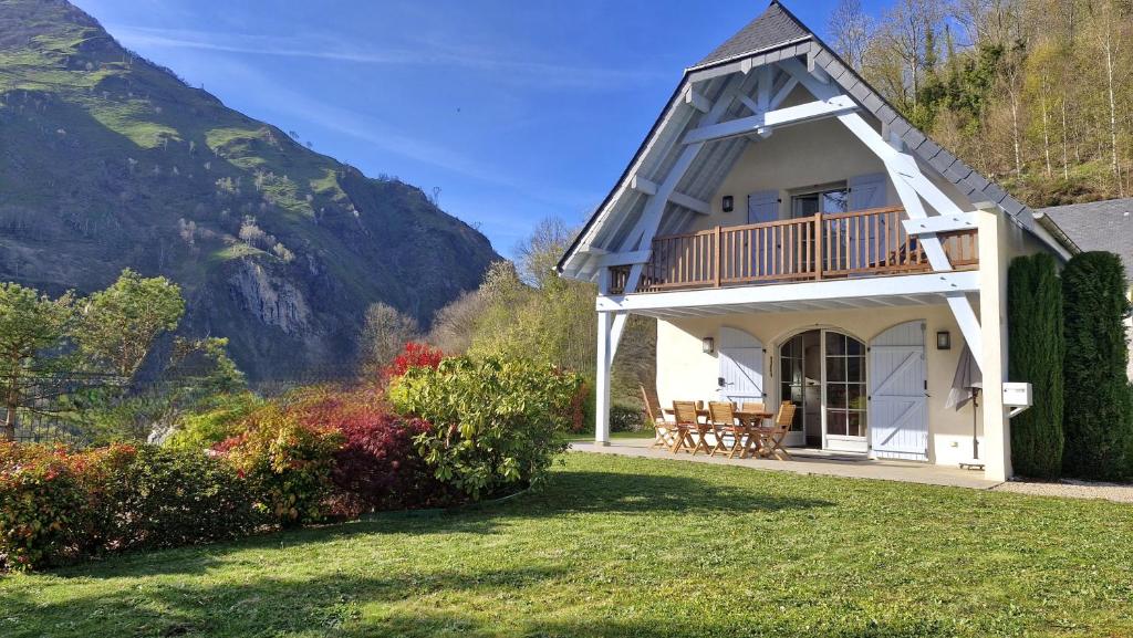a house with a balcony with a view of the mountains at Les hauts de LOUVIE in Louvie-Soubiron