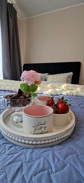 a tray with strawberries on a bed with a trayngthngthngthngthngthngth at Rohu Apartment in Pärnu