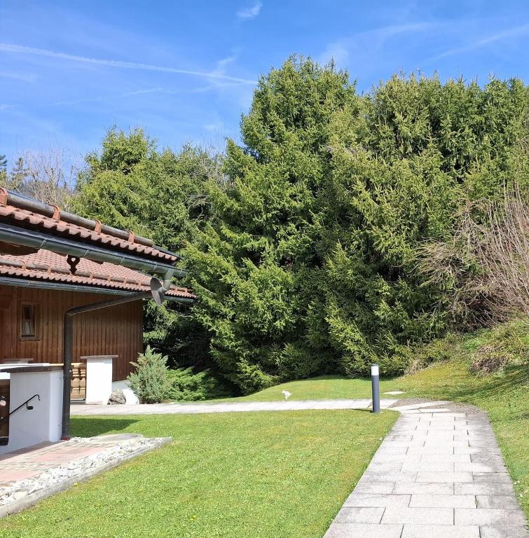 a garden next to a house with a walkway at Bodenschneidsuiten Luxburg in Tegernsee