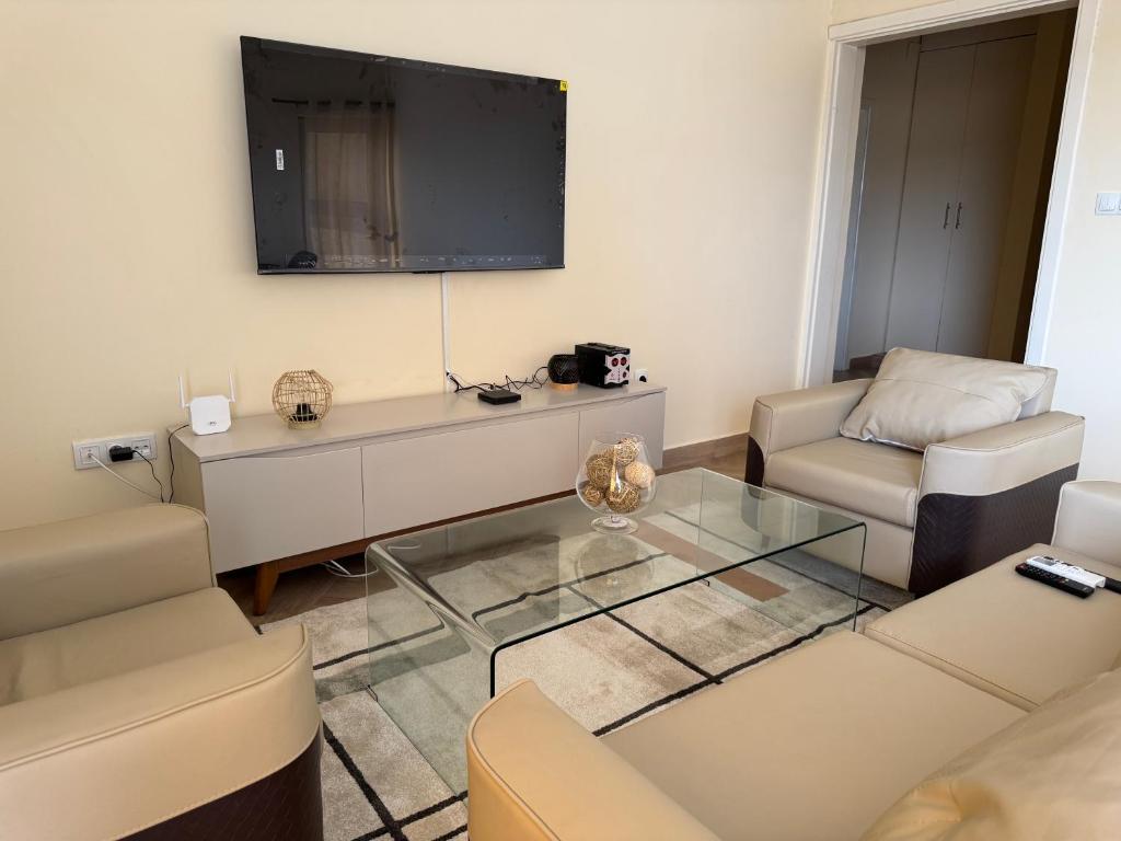a living room with a couch and a tv at Appartements modernes, Wifi, TV - Yaoundé, Omnisports in Yaoundé