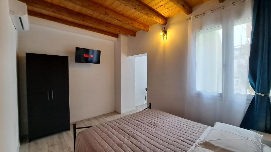 a bedroom with a bed and a large window at Monte Ricco Appartamenti in Monselice