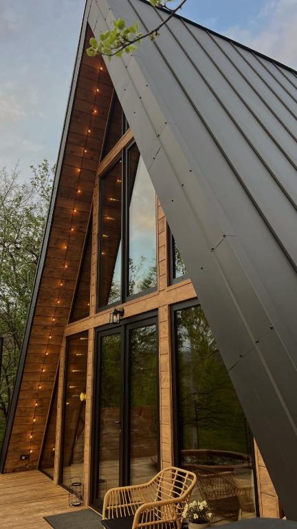 a house with large windows and a roof at BRUN Cabin in Şotrile