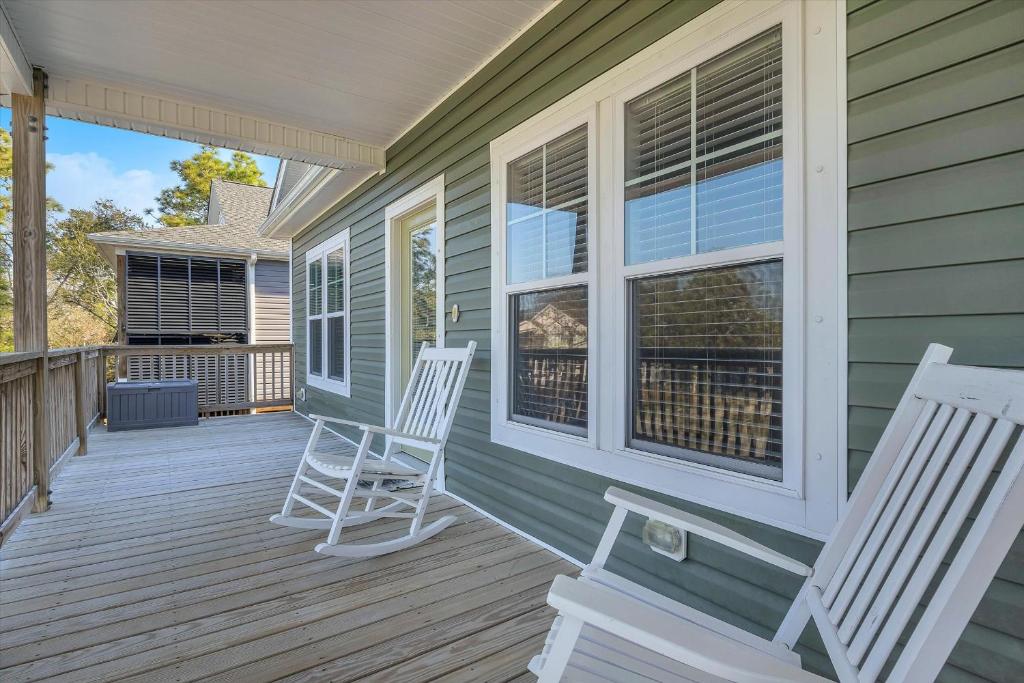 a porch with two chairs on a house at All Summer Long by Oak Island Accommodations in Oak Island