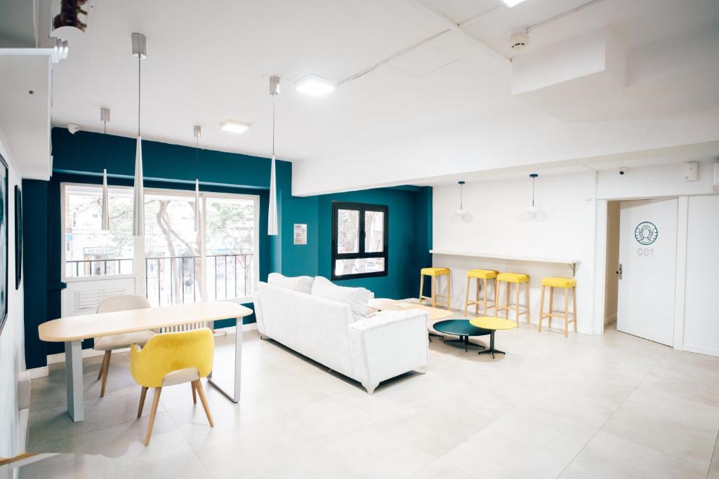 a living room with a couch and a table and chairs at MadVibes Hostel Gran Vía in Madrid