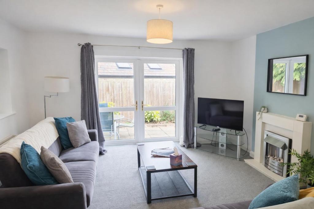 a living room with a couch and a tv at Large 2-Bedroom Bungalow near Airedale Hospital, Keighley, Convenient Location with Parking in Steeton