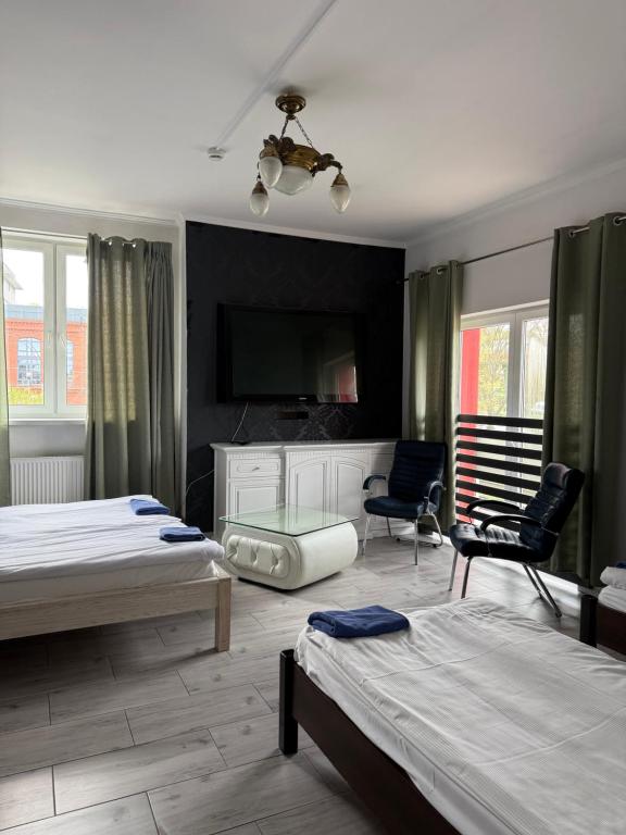 a bedroom with two beds and a flat screen tv at AtmosferA in Bydgoszcz