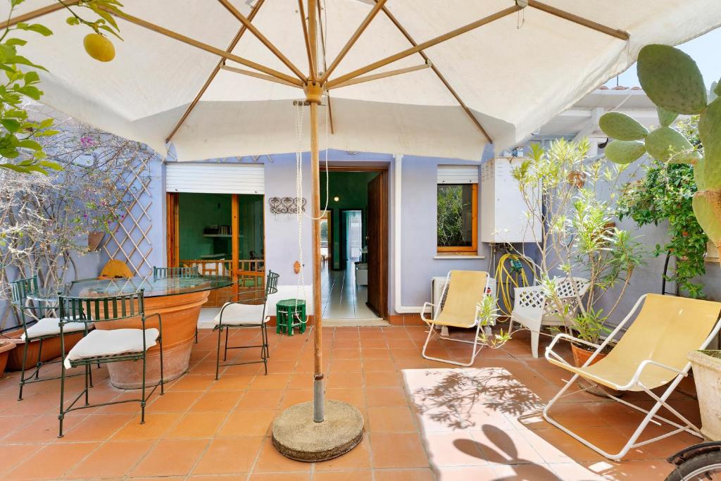 a patio with a table and an umbrella at Casa Vacanze Bouganvillea in Sabaudia