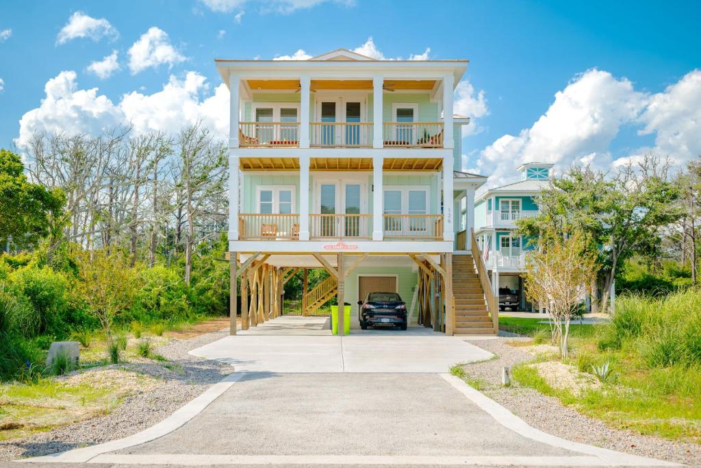 a house with a car parked in the driveway at All Sands On Deck by Oak Island Accommodations in Oak Island
