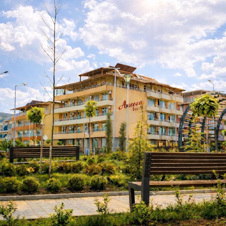 a large building with a roller coaster in the background at Hotel Ancora Beach in Primorsko