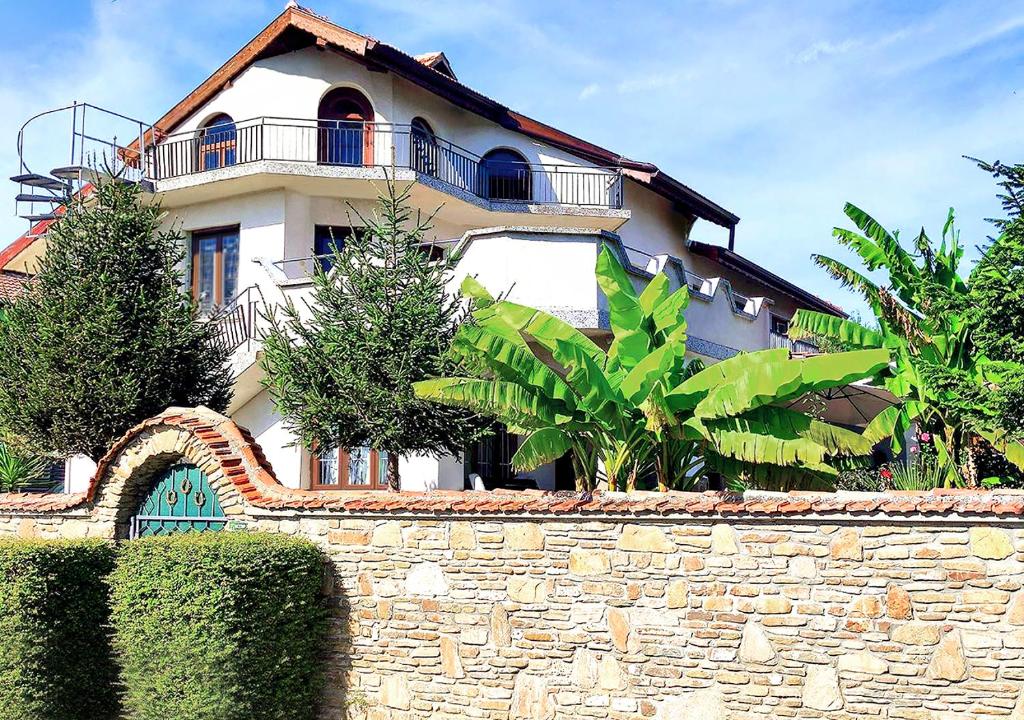a house with a stone wall and a building at Guest House - Heaven in Byala