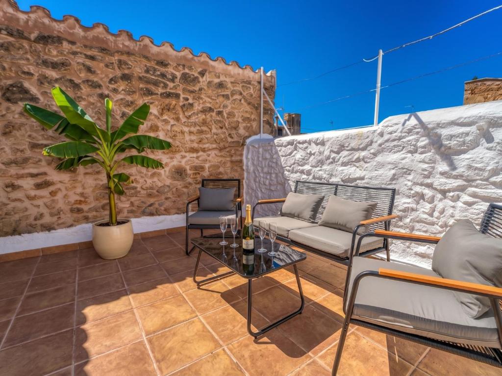 a patio with chairs and a table and a plant at Ideal Property Mallorca - Corro Sant Jaume in Alcudia
