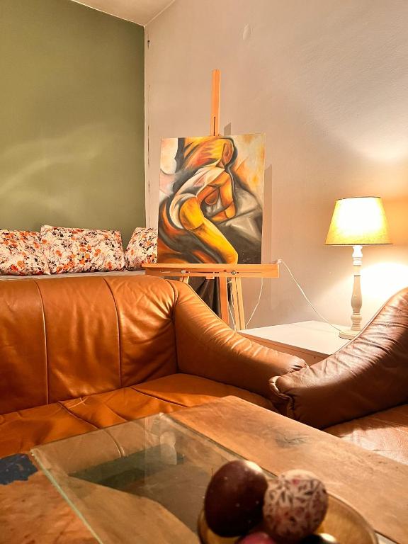 a living room with a leather couch and a painting at Apartment 16 in Probištip