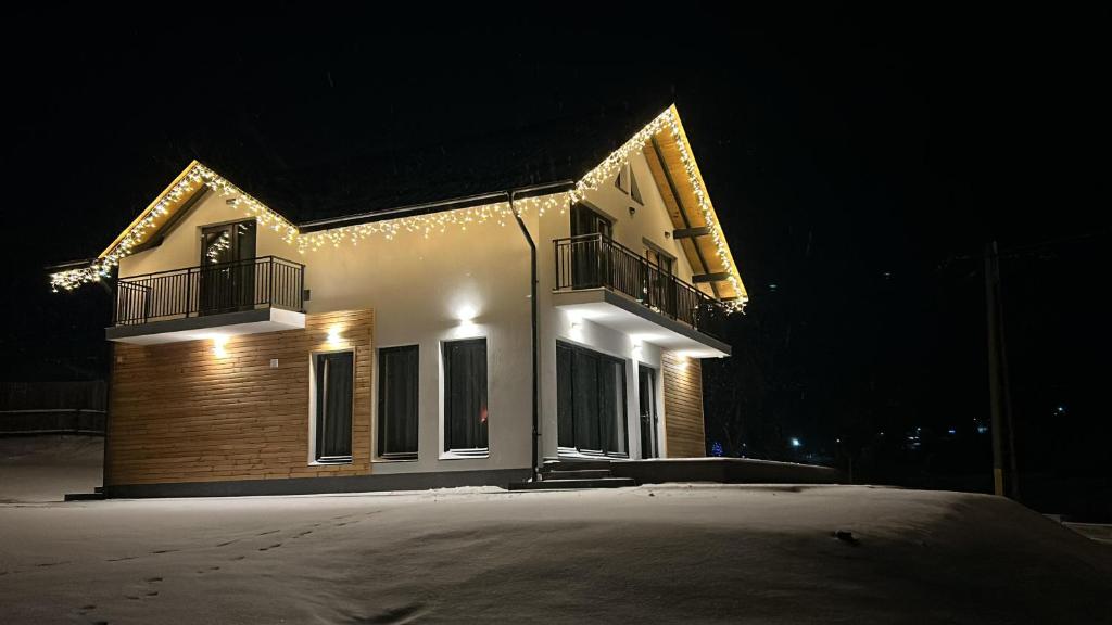 a house with lights on the side of it at night at Pe Coastă in Cozăneşti