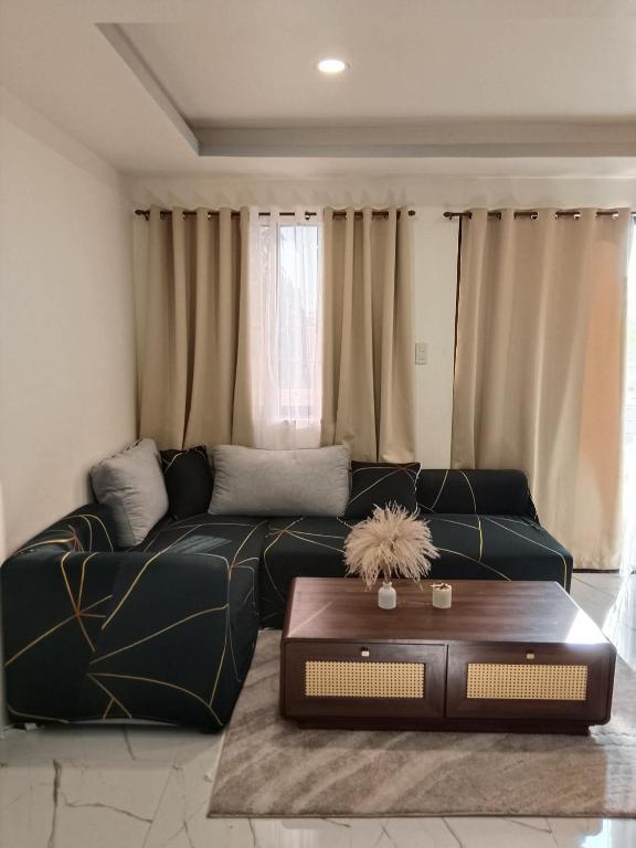 a living room with a black couch and a table at Home stay in Pasig in Pasig