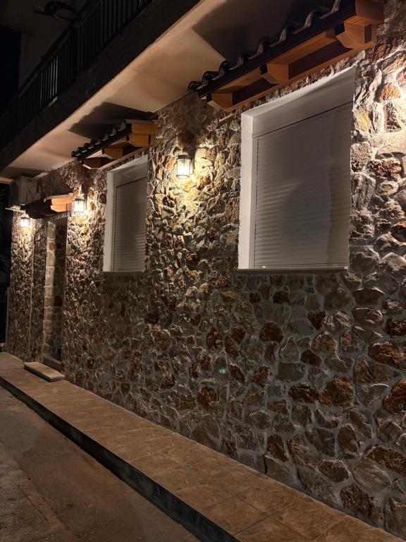 a stone wall with two windows and lights at Stone house 48 m in Acharnes