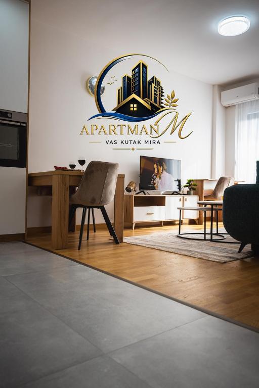 a room with a sign on a wall with a table and chairs at ApartmanMFoca in Foča