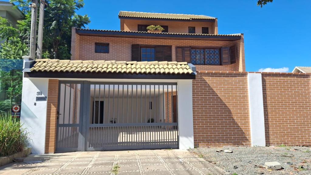 a brick house with a garage in front of it at Pousada Solar Curitiba in Curitiba