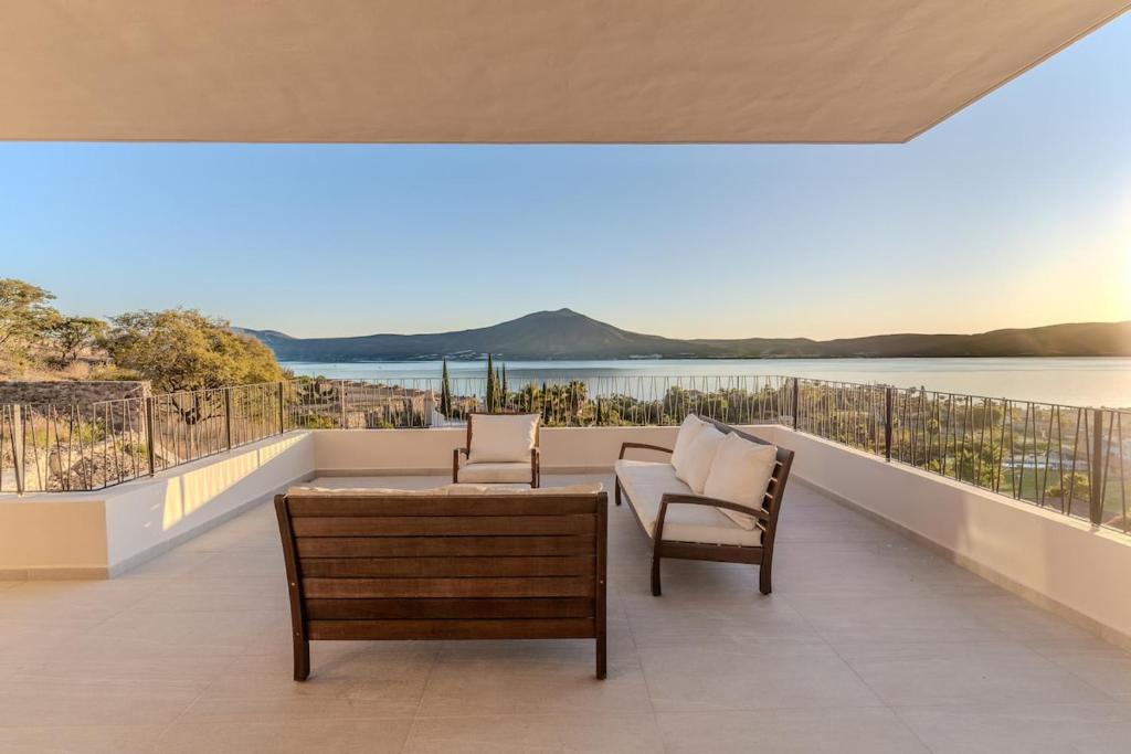 a balcony with chairs and a table and a view of the water at Casa Ambar Luxury Lake View Villa Pool Design in San Juan Cosalá