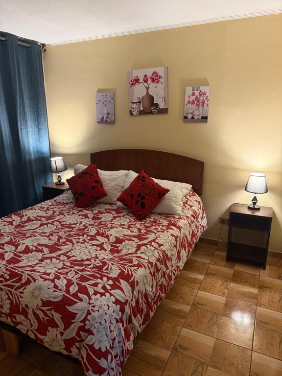 a bedroom with a bed with red pillows on it at 703 Departamento 15 minutos de Aeropuerto Maipu in Santiago