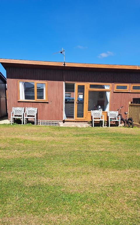 a group of chairs sitting outside of a house at Beside the Seaside Chalet in Mablethorpe