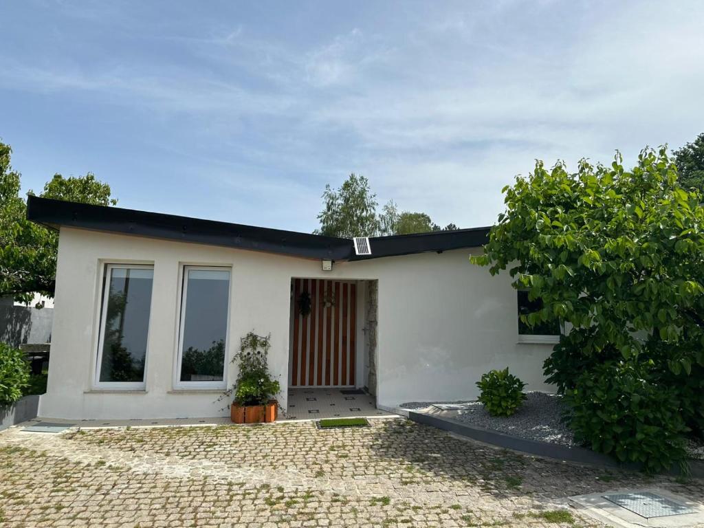 a small white house with a tree at Casa de Ferias Tranquilo in Bitarães