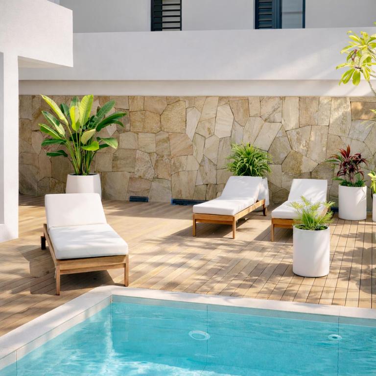 a swimming pool with two chairs and a swimming pool at Ti Paradis with Private rooftop in Grand-Baie