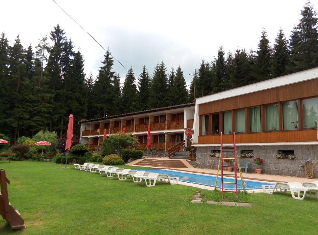 a hotel with a swimming pool in front of a building at Lesní pension in Lipno nad Vltavou