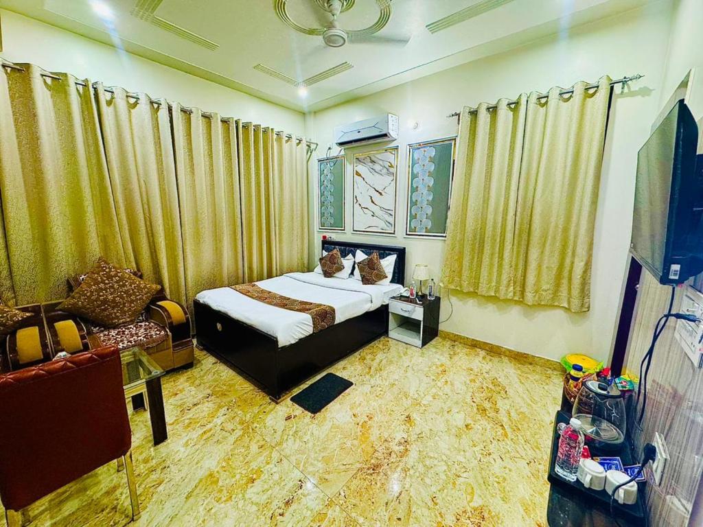a bedroom with a bed with two cats sitting on it at Hotel Keptown in Patna
