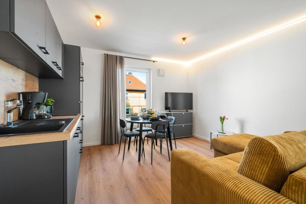 a kitchen and a living room with a table and chairs at Studio 03 - Einzimmerapartment klimatisiert in Friedrichshafen