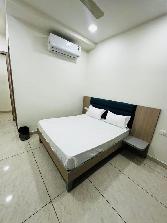 a bedroom with a bed with white sheets and pillows at Hotel Loya Bti in Bathinda