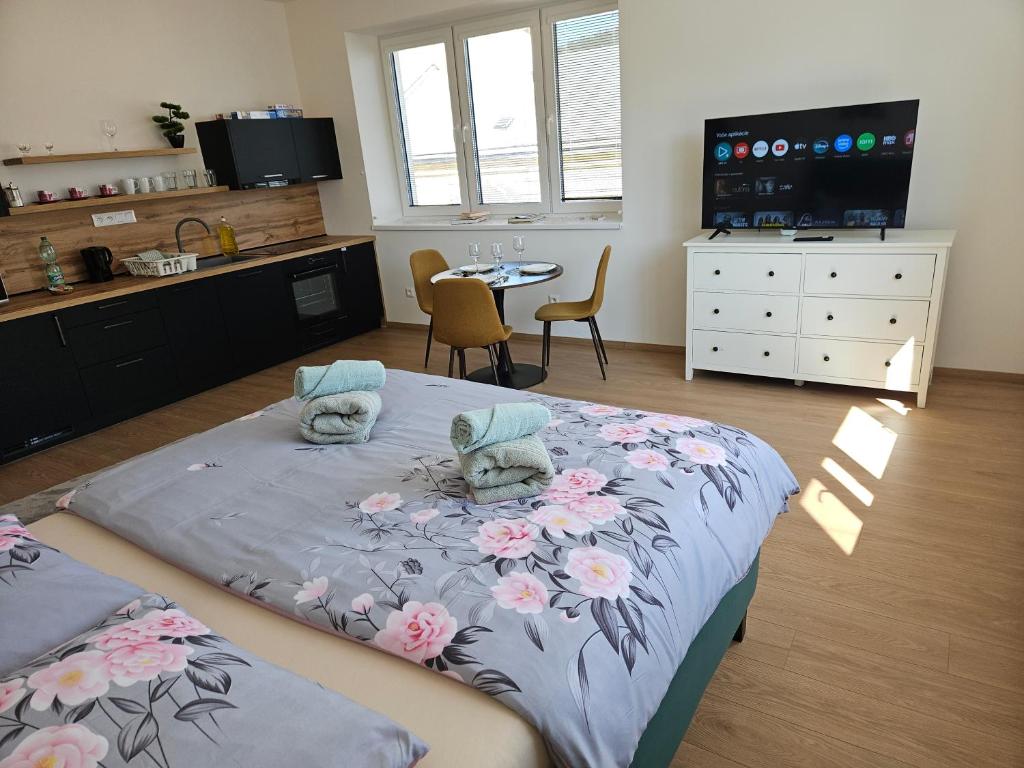 a bedroom with a large bed with flowers on it at Apartmán KVETINKA v centre Žiliny s KAVIARŇOU in Žilina