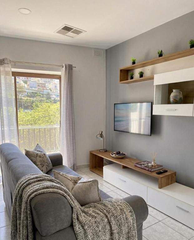 a living room with a couch and a flat screen tv at St Julians Mansion Rooms in St. Julianʼs