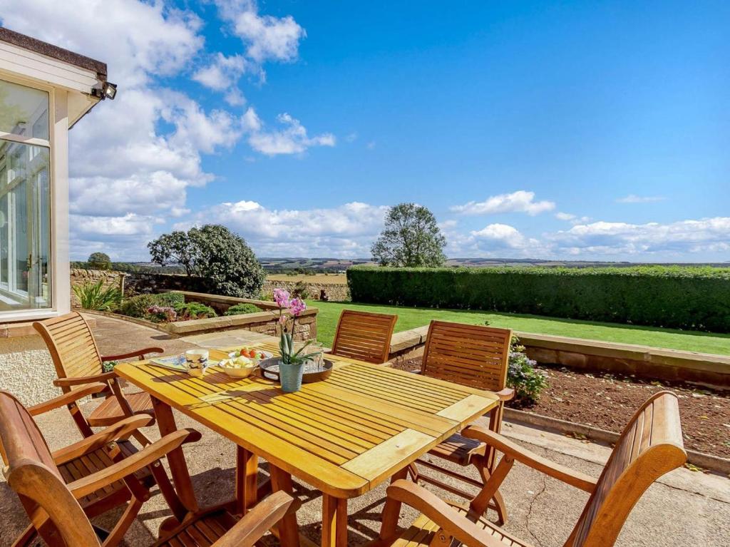 a wooden table and chairs on a patio at 4 Bed in Brechin oc-89698 in Brechin