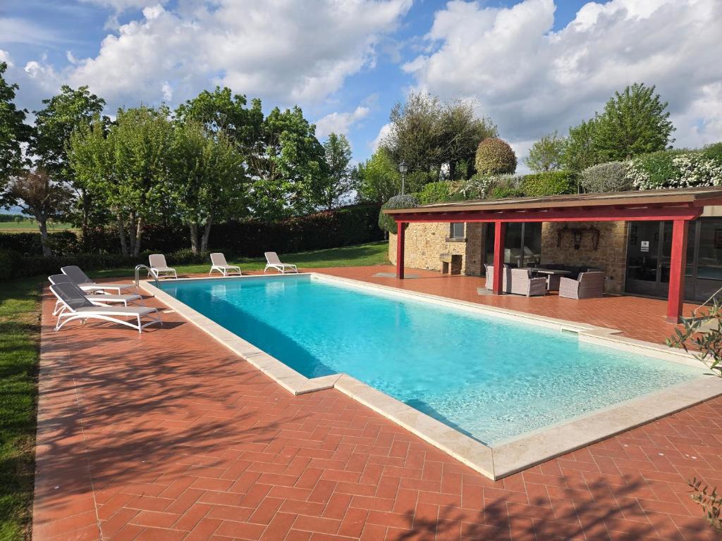 a swimming pool with chairs and a house at Leopoldina L'Orto in Arezzo