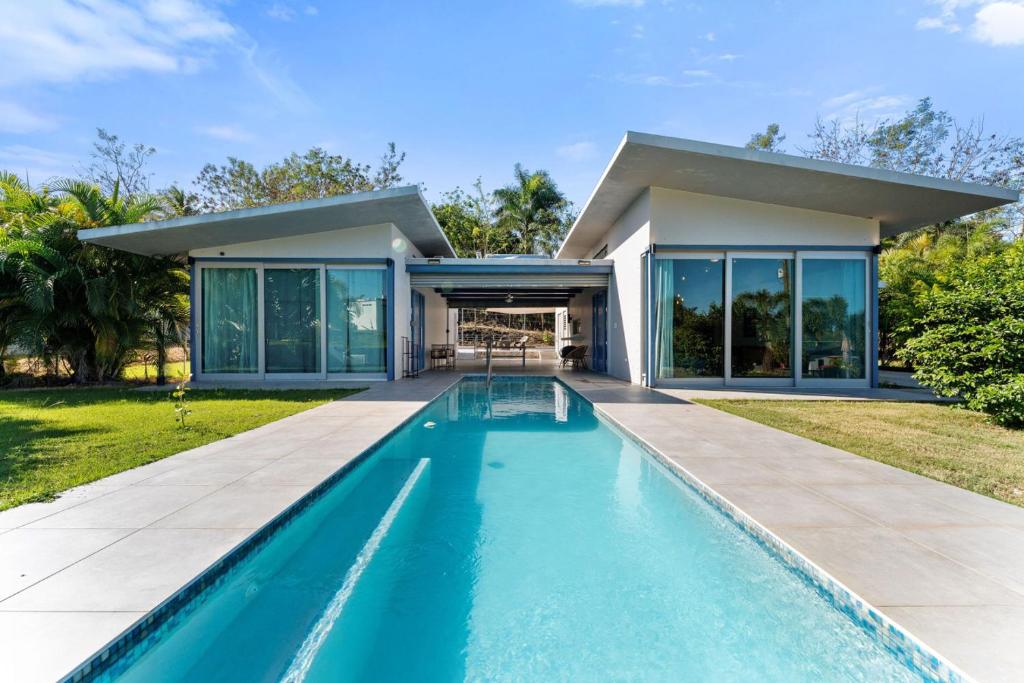 a swimming pool in front of a house at Casa Palma y Sol with private pool in Aguada