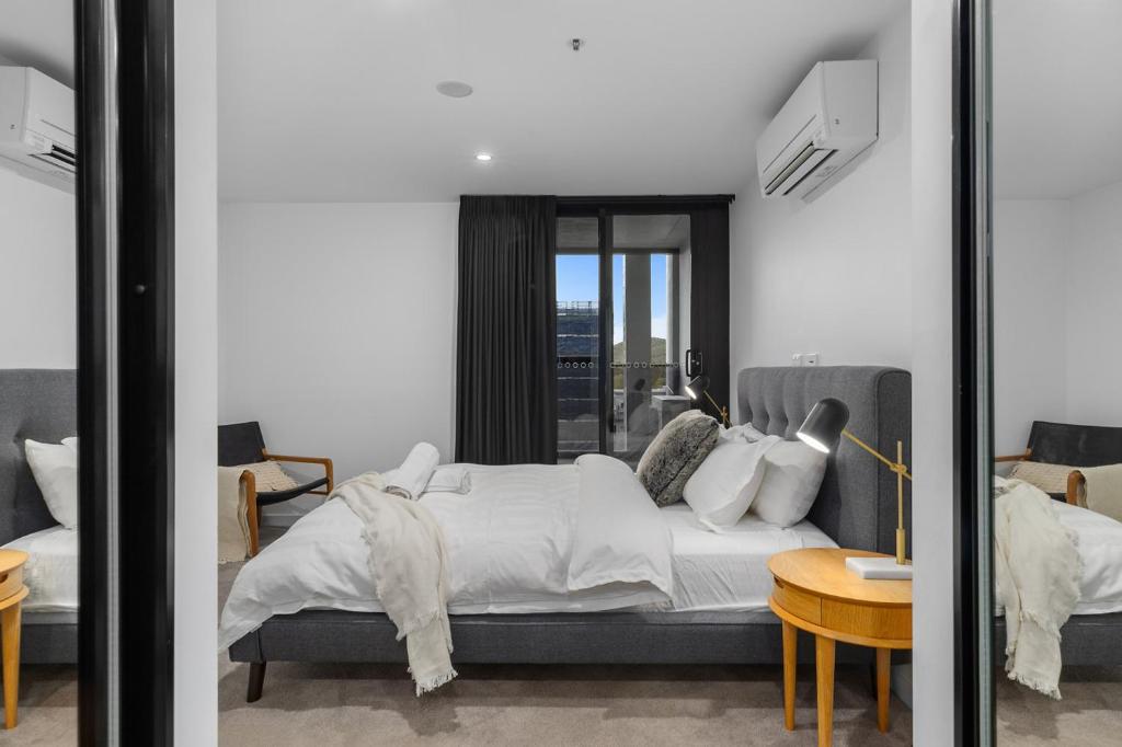 a bedroom with a bed and a table and a mirror at The Piastri at Midnight in Braddon