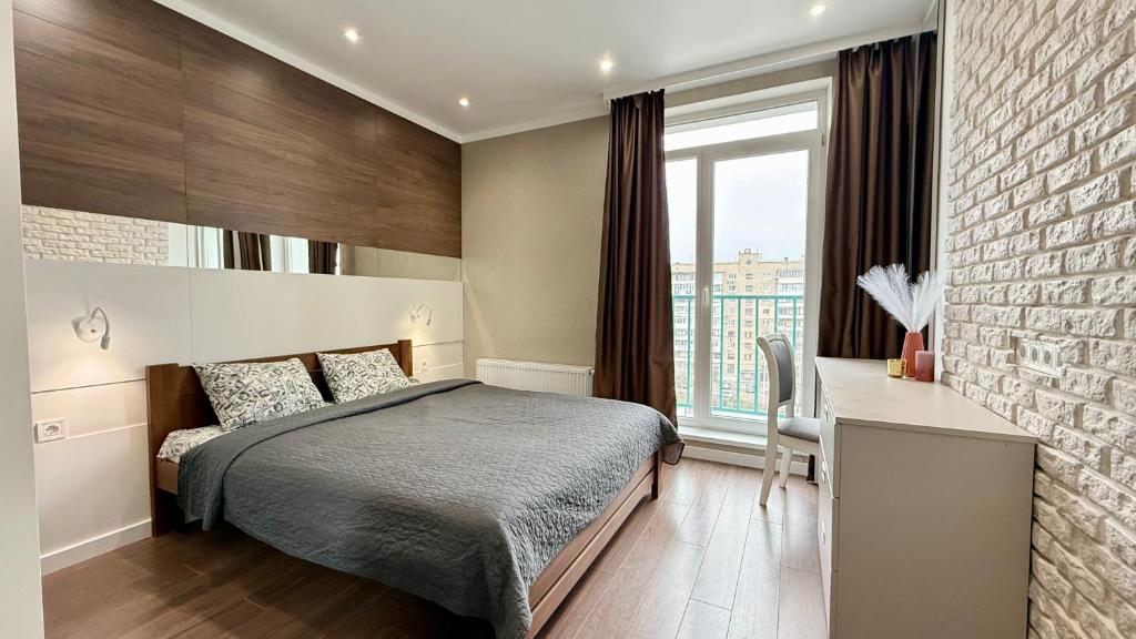 a bedroom with a bed and a brick wall at Naykova district Apartments in Kharkiv