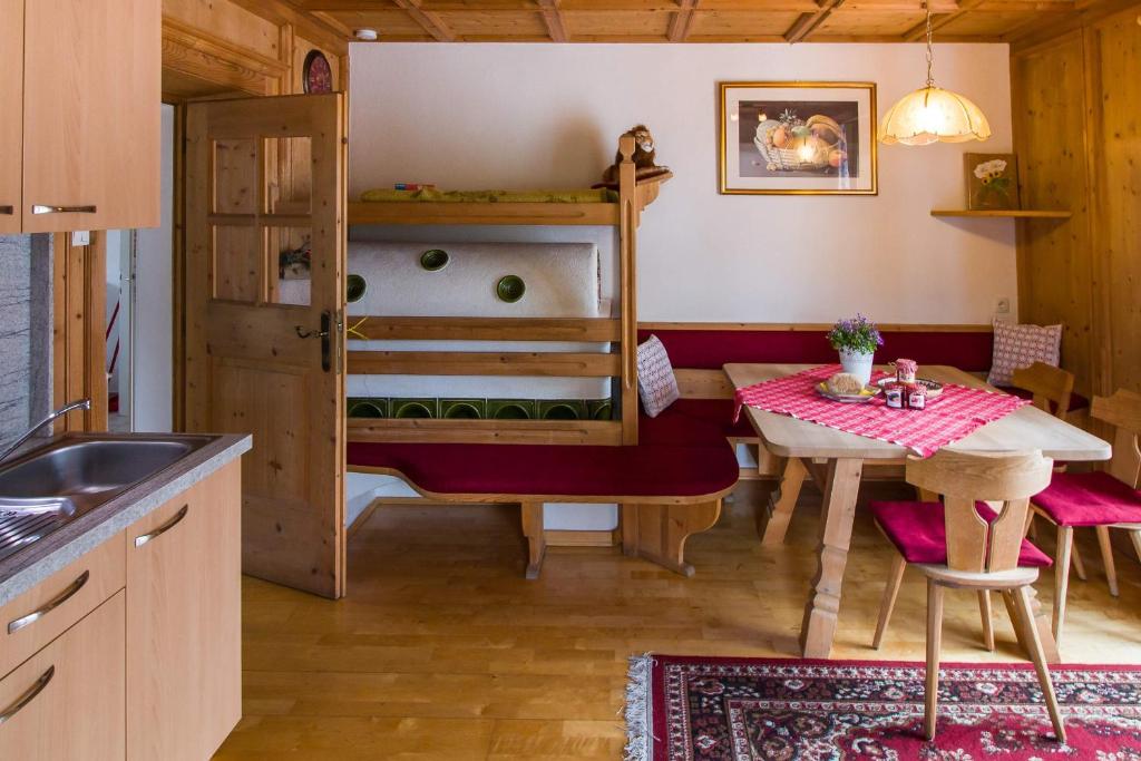 a kitchen with a table and a dining room at Haus Ploner - Pichlerhof in Chienes