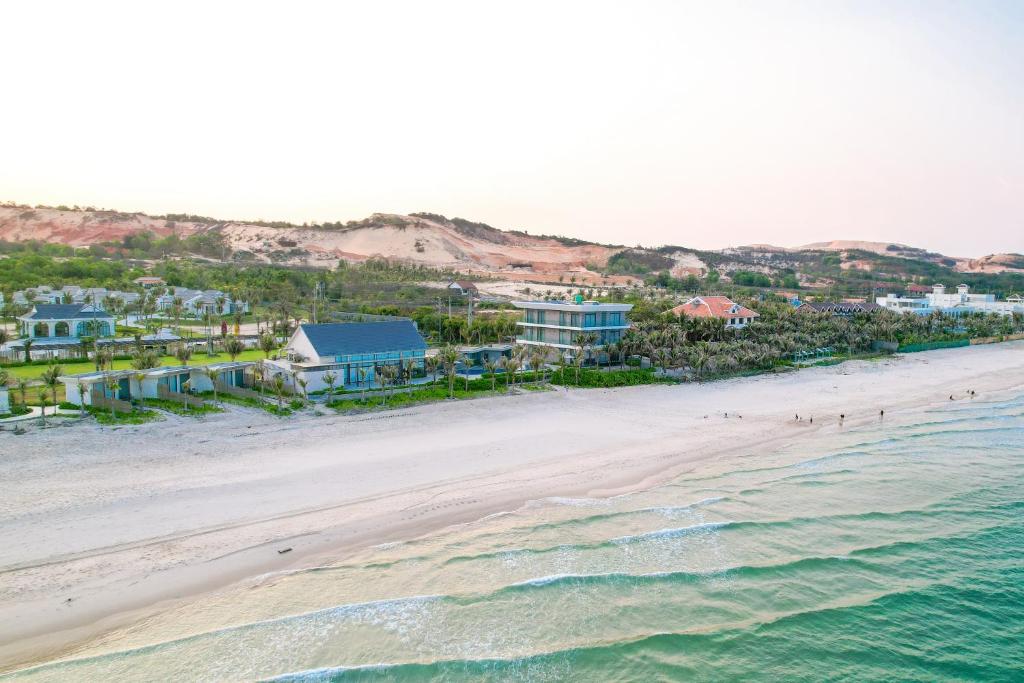 an aerial view of a beach with houses and the ocean at Polaris Resort & Spa in Xóm Tram