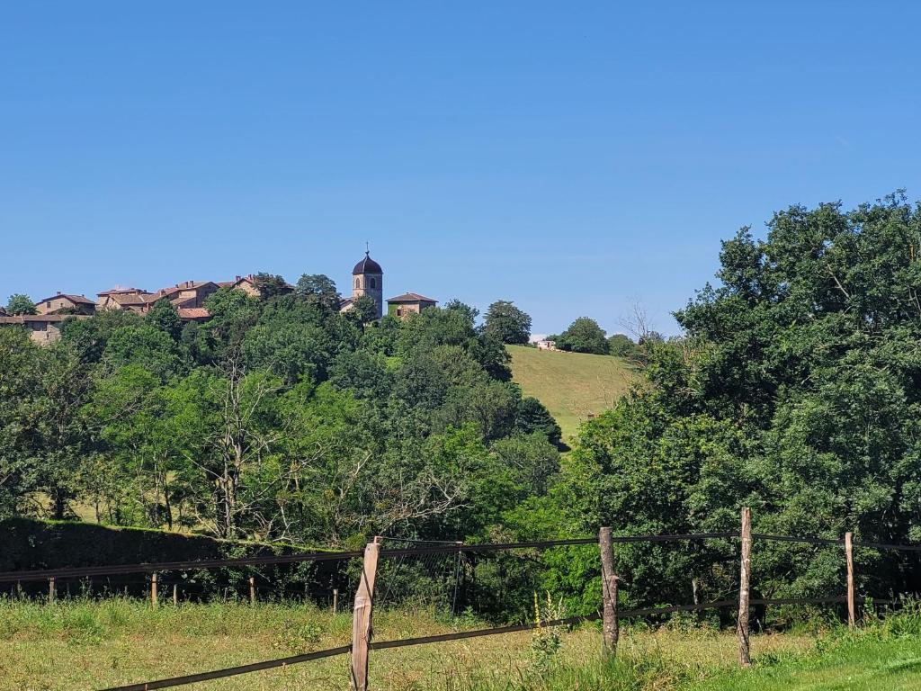 a fence in a field with a house on a hill at L'écrin de Sérénité - CNPE Bugey - Meximieux in Meximieux