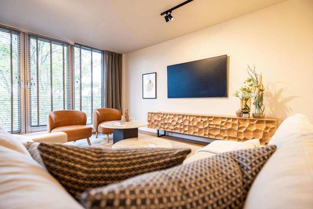 a living room with a couch and a flat screen tv at Stylische Penthouse - Maisonette - Wohnung im edlem Design mit Balkon, Dachterrasse und kostenloser Tiefgarage im Herzen von Markkleeberg - Neuseenland in Markkleeberg