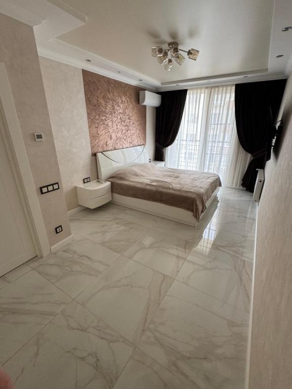 a bedroom with a bed and a large marble floor at Golden Era Relax in Odesa