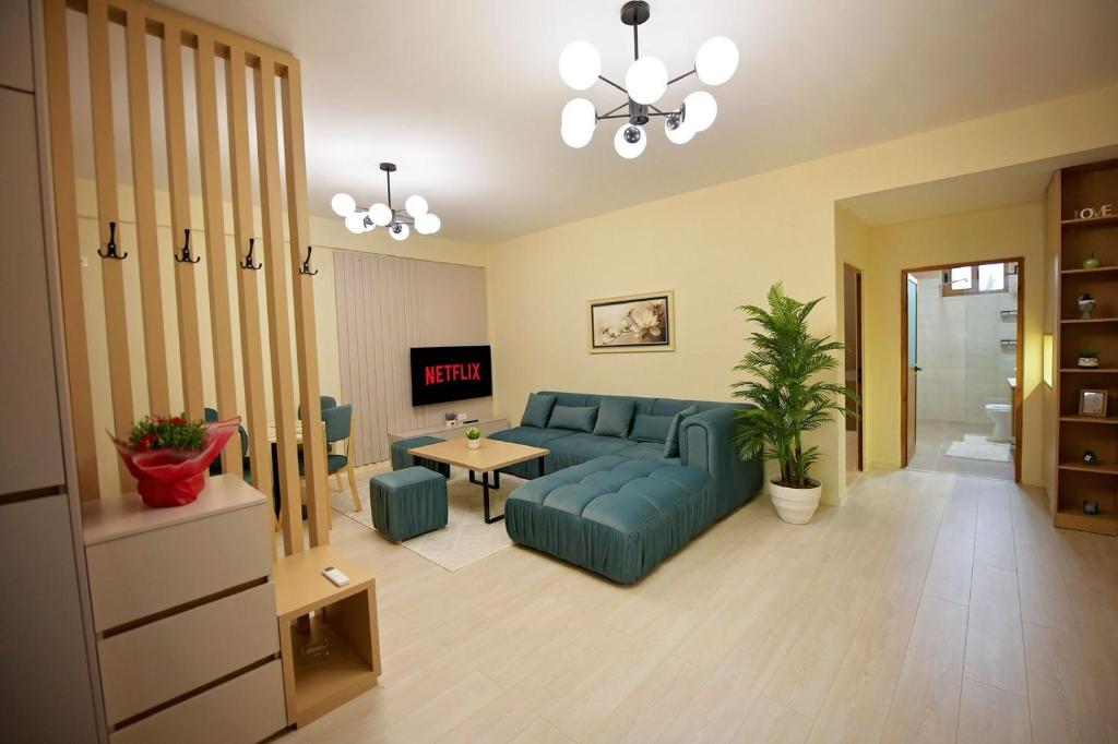 a living room with a blue couch and a table at Dedi Apartment 1 in Shkodër